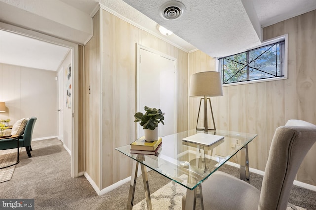 carpeted office space with a textured ceiling, crown molding, and wood walls