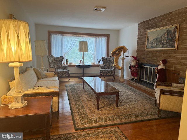 sitting room with baseboard heating, a large fireplace, and dark hardwood / wood-style flooring