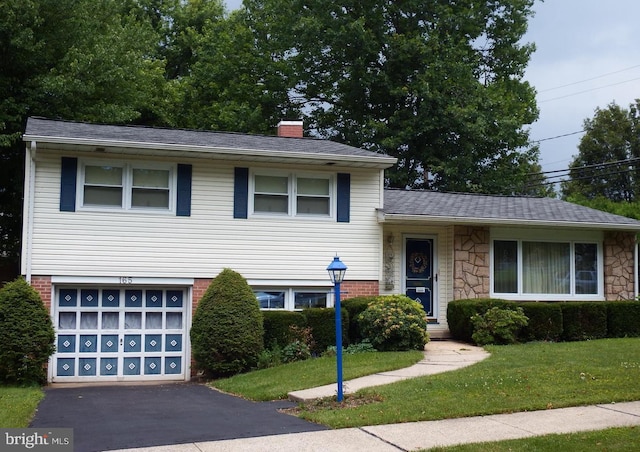 split level home with a front lawn and a garage