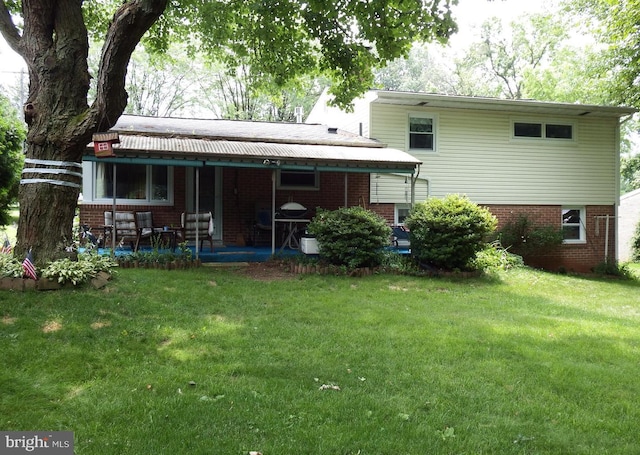 rear view of property with a patio and a yard