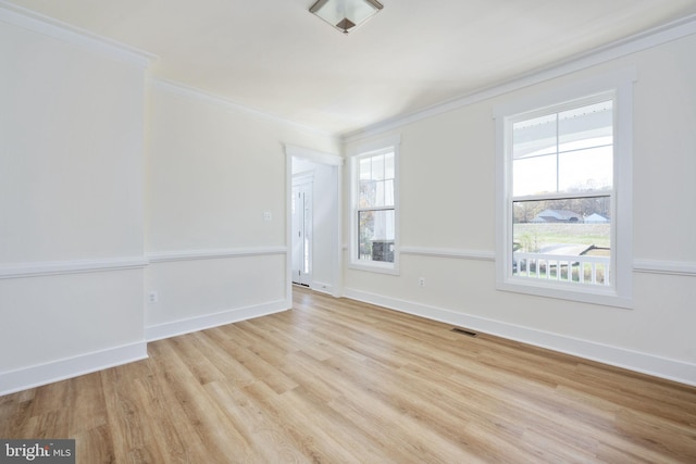 spare room with crown molding and light wood-type flooring