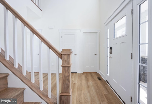 entrance foyer featuring a high ceiling and light wood-type flooring