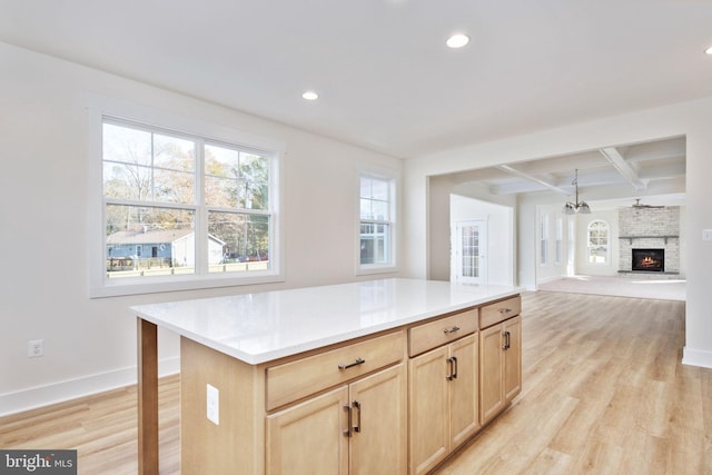 kitchen featuring coffered ceiling, light hardwood / wood-style flooring, light brown cabinets, and a kitchen island