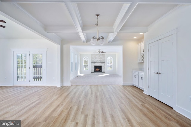 unfurnished living room featuring coffered ceiling, a fireplace, beamed ceiling, and light wood-type flooring