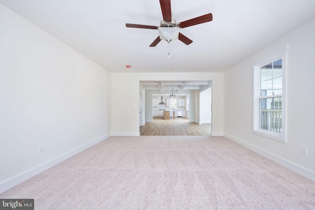 unfurnished living room with light colored carpet and ceiling fan