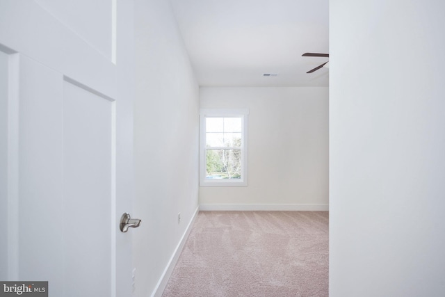 spare room featuring light carpet and ceiling fan