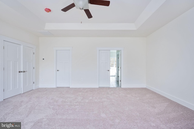 carpeted spare room featuring a raised ceiling