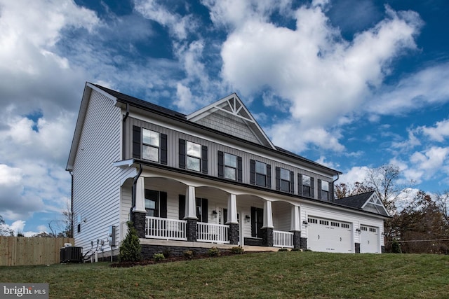 view of front of home featuring a porch, a garage, a front yard, and central air condition unit