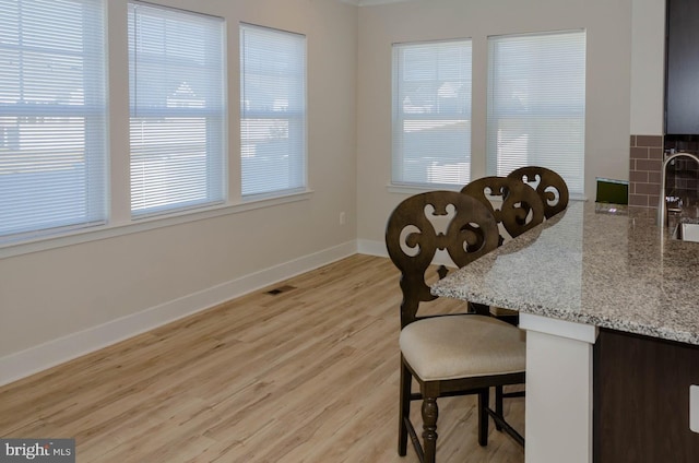 dining area with sink and light hardwood / wood-style floors