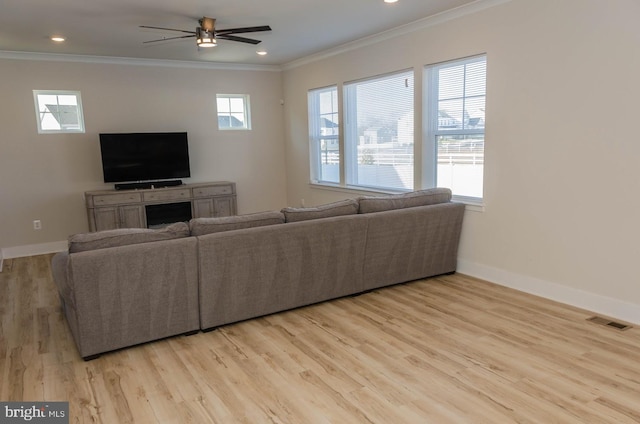 living room with ornamental molding, ceiling fan, and light hardwood / wood-style flooring