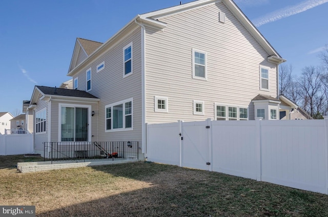 rear view of house featuring a yard