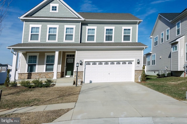 view of front of home featuring a garage, a porch, and a front lawn