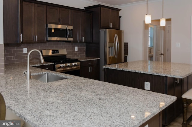 kitchen with dark brown cabinetry, stainless steel appliances, light stone countertops, and hanging light fixtures