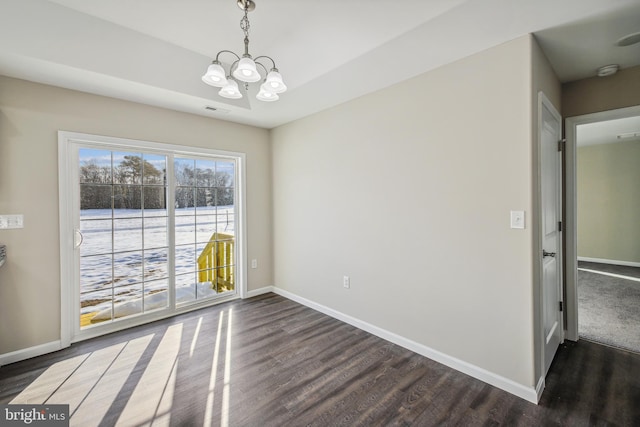 unfurnished room with dark wood-type flooring and a notable chandelier