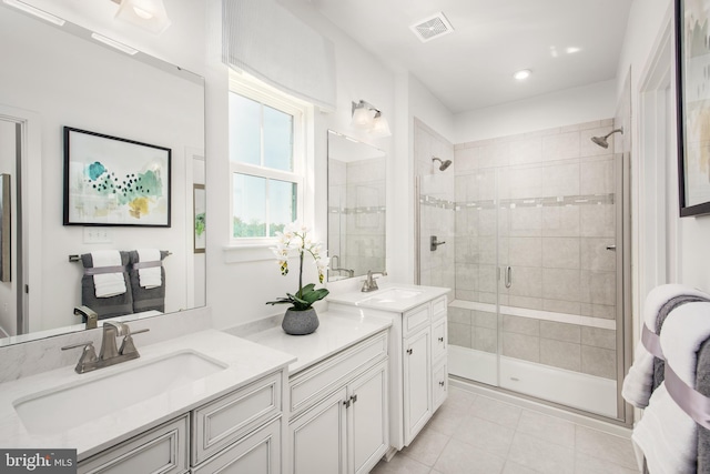 bathroom featuring tile patterned floors, a shower with door, and vanity