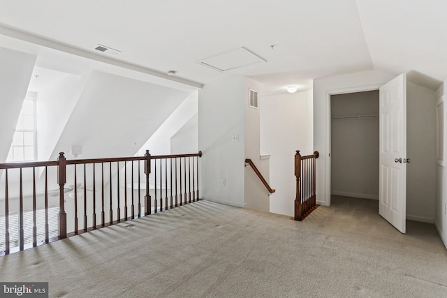 hallway with lofted ceiling and light carpet