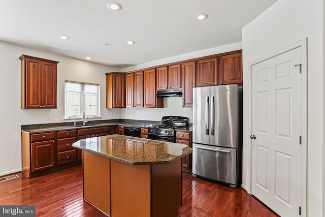 kitchen with a kitchen island, sink, dark stone countertops, black appliances, and dark wood-type flooring