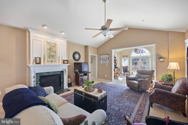 living room featuring lofted ceiling, a fireplace, ceiling fan, and carpet flooring