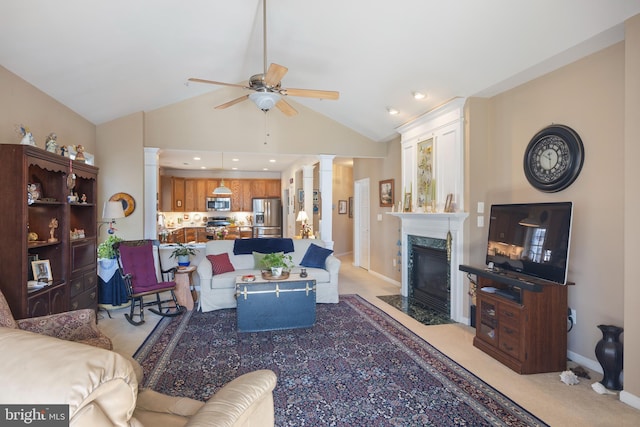 carpeted living room featuring ceiling fan, lofted ceiling, a high end fireplace, and ornate columns