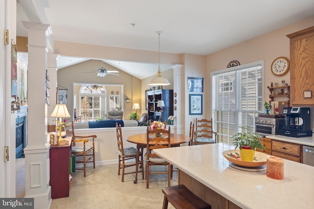 kitchen featuring ornate columns, vaulted ceiling, a fireplace, decorative light fixtures, and ceiling fan