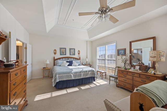 carpeted bedroom featuring a raised ceiling and ceiling fan