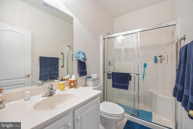 bathroom with toilet, vanity, tile patterned floors, and walk in shower