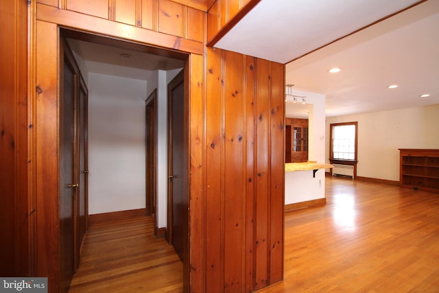 corridor featuring light hardwood / wood-style flooring and radiator heating unit