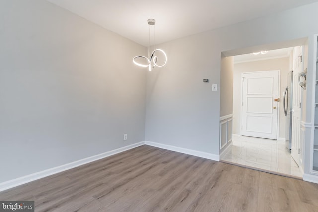 unfurnished dining area with light hardwood / wood-style flooring and a notable chandelier