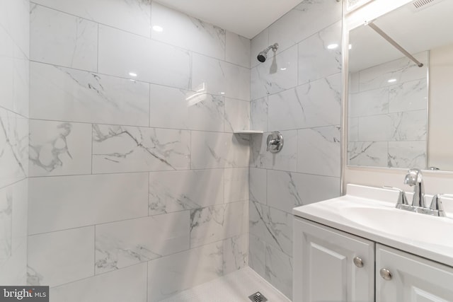 bathroom with vanity and a tile shower