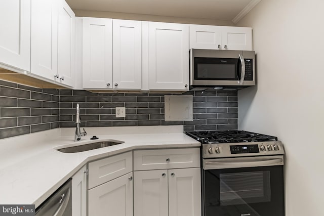 kitchen with white cabinets, decorative backsplash, sink, and stainless steel appliances