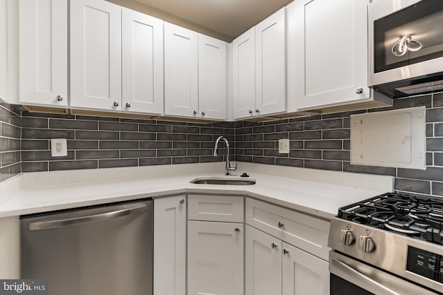 kitchen featuring white cabinets, backsplash, sink, and stainless steel appliances