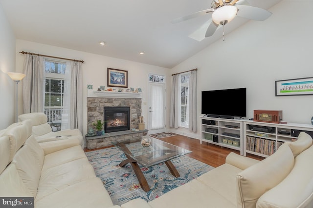 living room with lofted ceiling, wood-type flooring, a fireplace, and ceiling fan