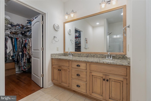 bathroom featuring walk in shower, tile patterned floors, and vanity