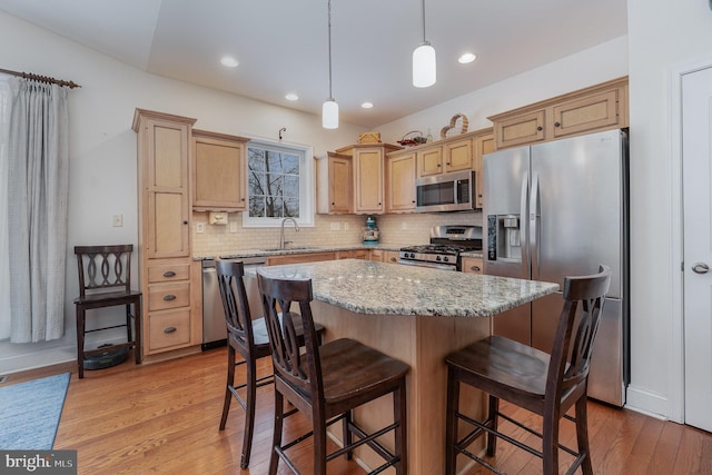 kitchen featuring decorative light fixtures, a center island, decorative backsplash, sink, and stainless steel appliances