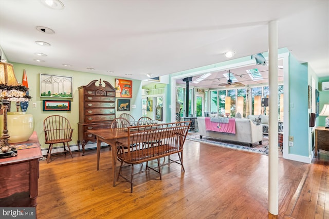 dining room with a baseboard heating unit, ceiling fan, and hardwood / wood-style flooring