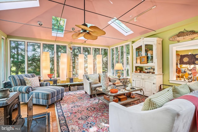 sunroom featuring ceiling fan and vaulted ceiling with skylight