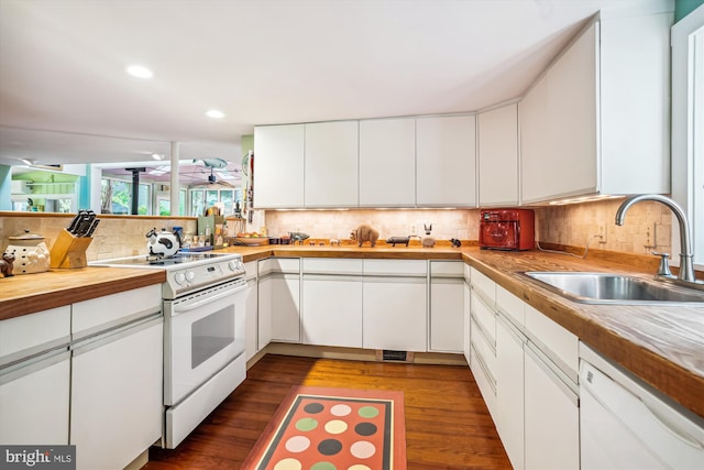 kitchen with backsplash, sink, white appliances, white cabinetry, and dark hardwood / wood-style flooring