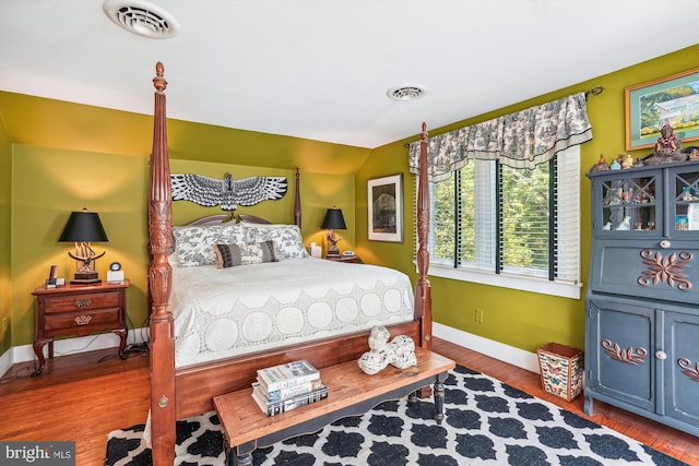 bedroom with hardwood / wood-style flooring and lofted ceiling