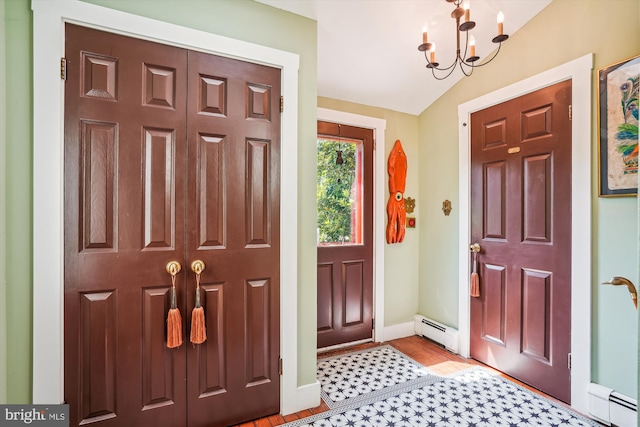 entryway with a notable chandelier, vaulted ceiling, light wood-type flooring, and a baseboard radiator