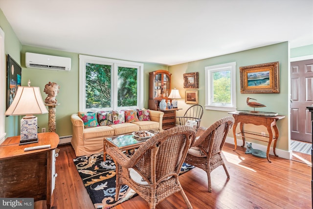 living room featuring a baseboard heating unit, wood-type flooring, and a wall mounted air conditioner