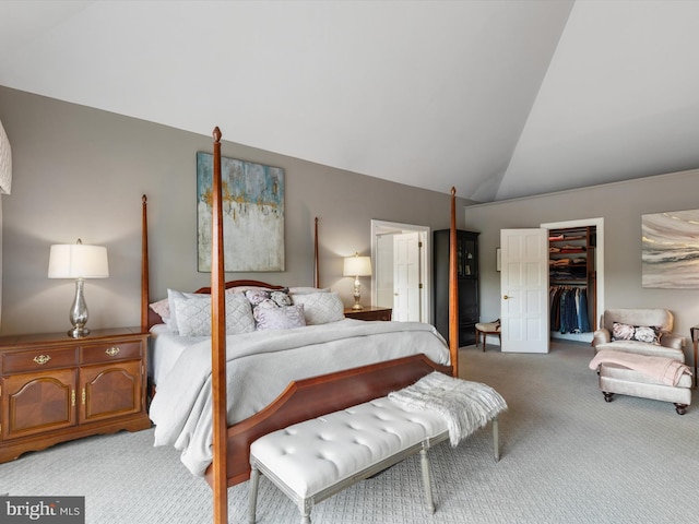 bedroom with lofted ceiling, light colored carpet, a closet, and a spacious closet