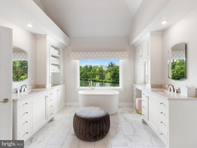 bathroom with a tub, plenty of natural light, and vanity