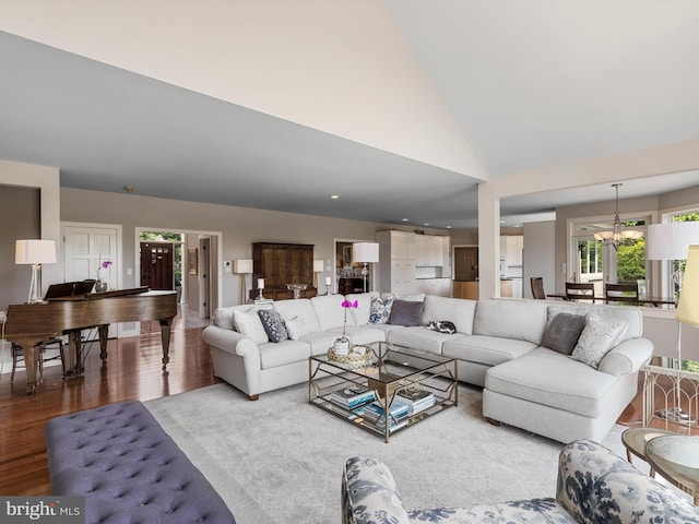 living room featuring a chandelier, hardwood / wood-style floors, and high vaulted ceiling