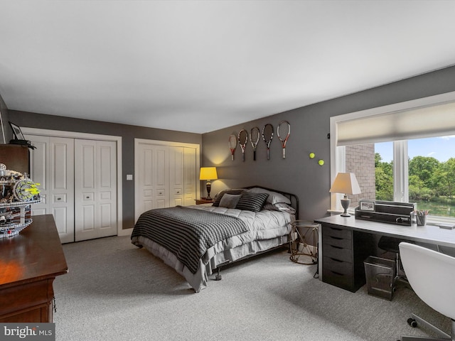 bedroom with multiple closets and carpet flooring