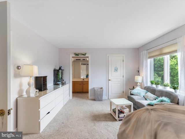 bedroom featuring light carpet and ensuite bath