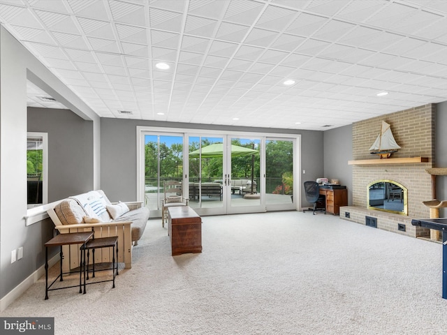 carpeted living room with a brick fireplace