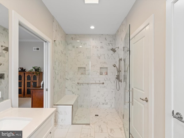 bathroom featuring ornamental molding, vanity, and a tile shower