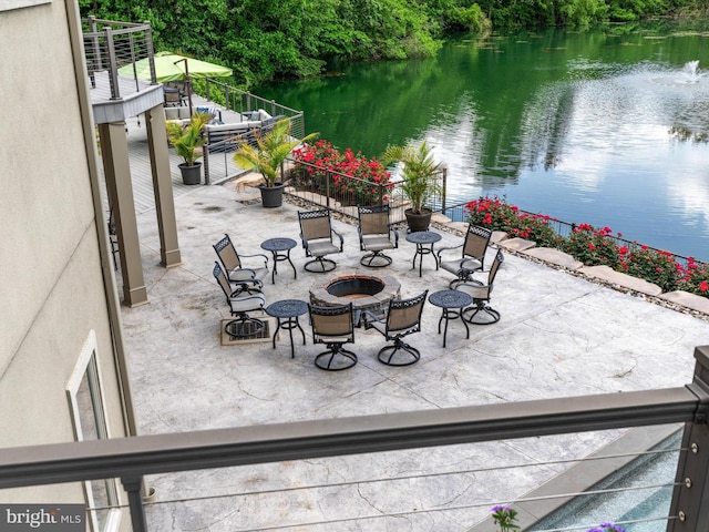 view of patio / terrace featuring a water view and a fire pit