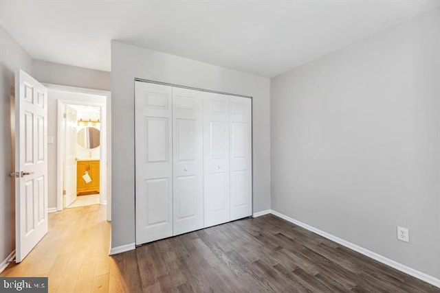 unfurnished bedroom featuring dark wood-type flooring and a closet