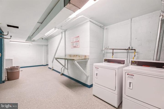 clothes washing area with washer and clothes dryer